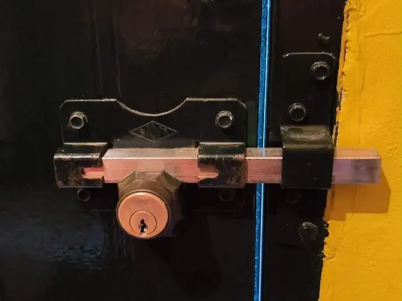 Cerrojo de seguridad con bombín en puerta metálica