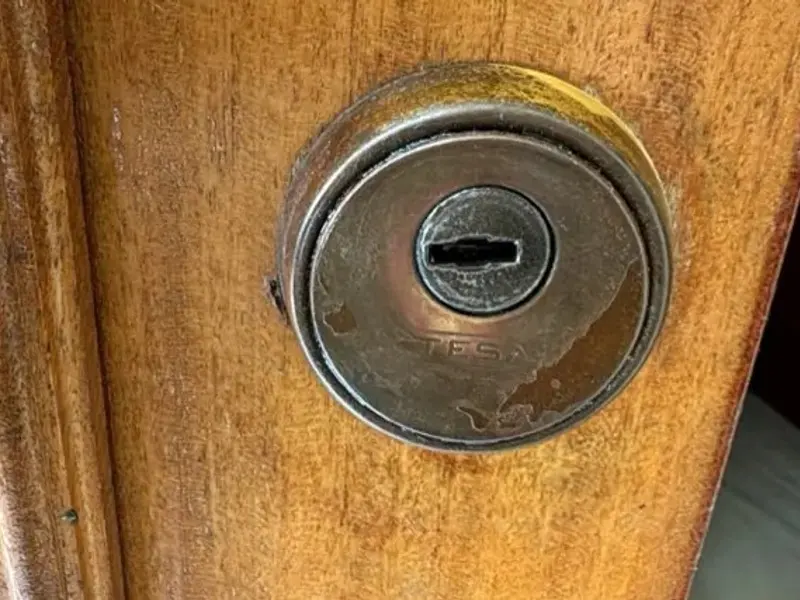 Escudo protector de bombín en puerta de madera