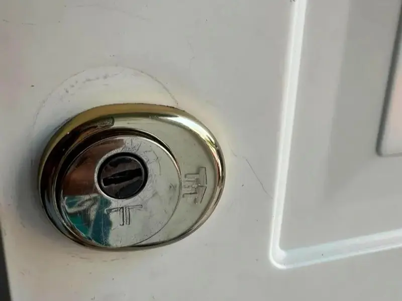 Escudo de seguridad sobre el bombín de una puerta blanca